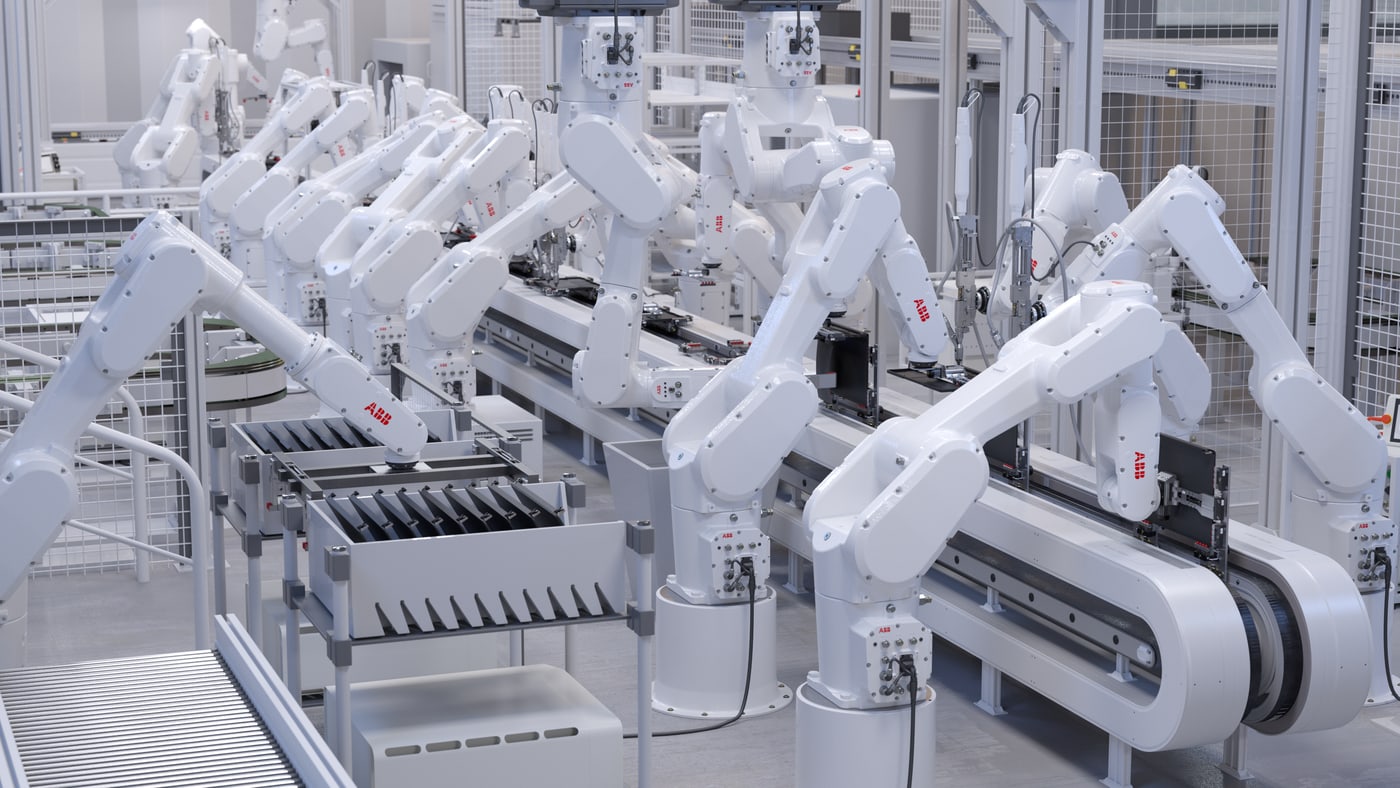 A row of robot arms working over an automated production line