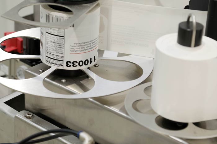 Bottles being labelled on a rotary applicator