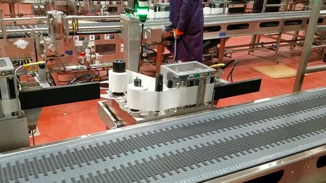An automated print-and-apply labeling line running over a conveyor