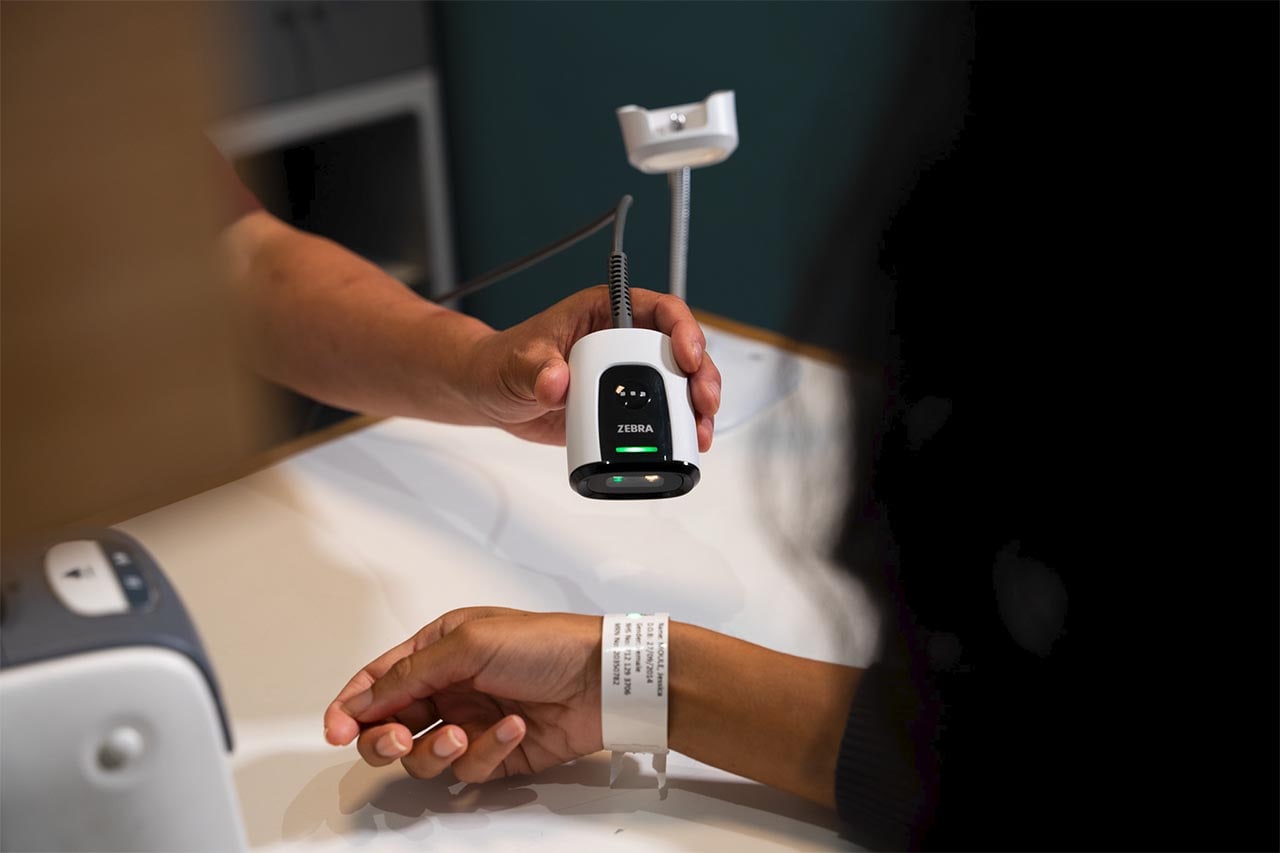 A DS55 on a presentation stand reading a wristband held beneath it