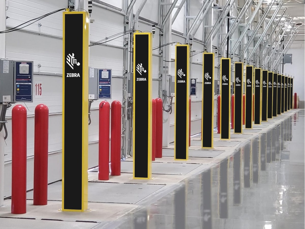 A row of RFID portal pedestals lining a warehouse aisle