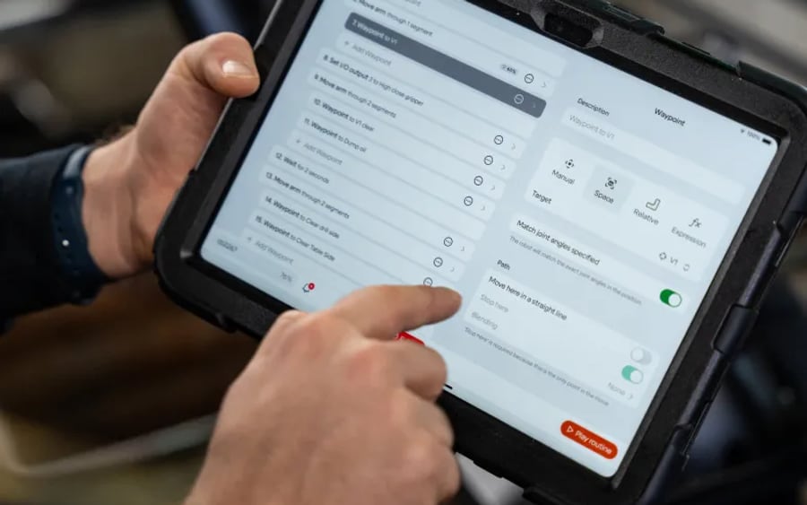 An operator programming a Standard Bots robot from a tablet interface