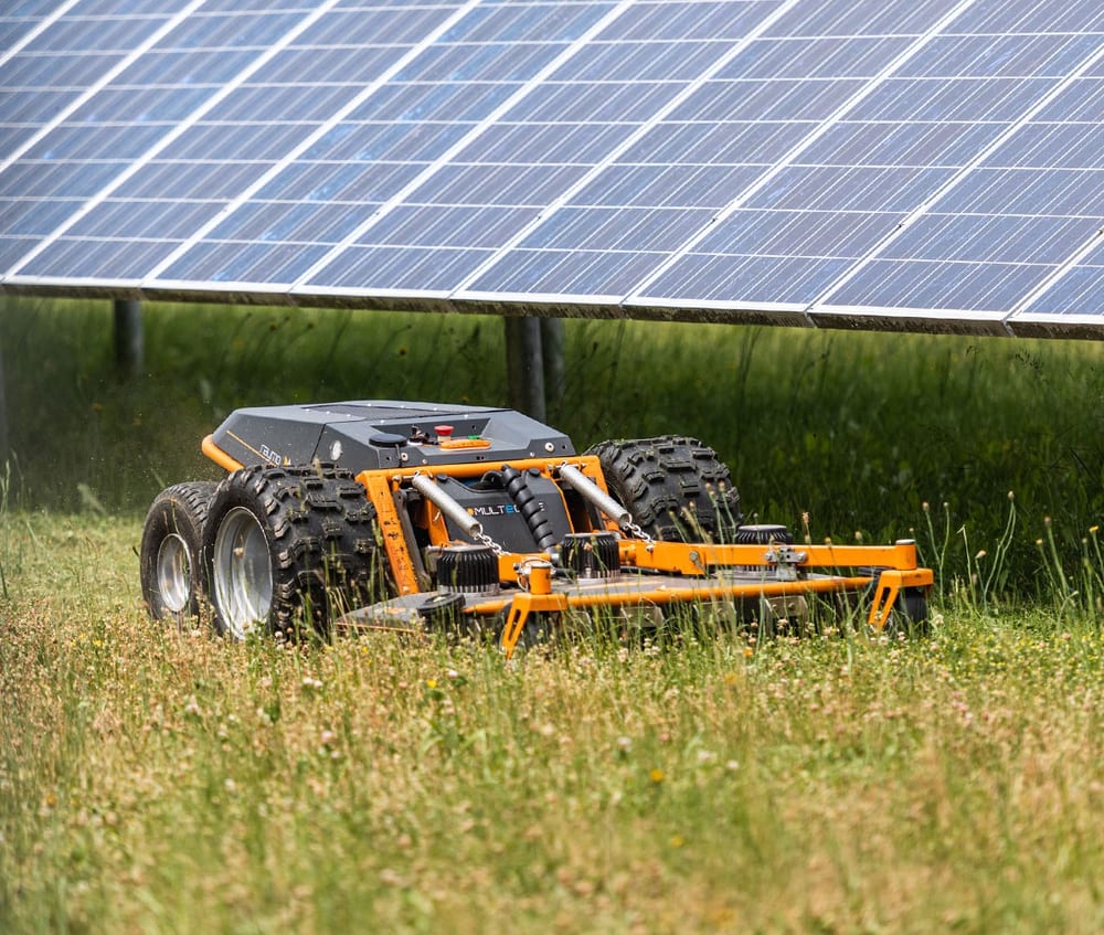 A Raymo R42FLEX mowing beneath solar panels